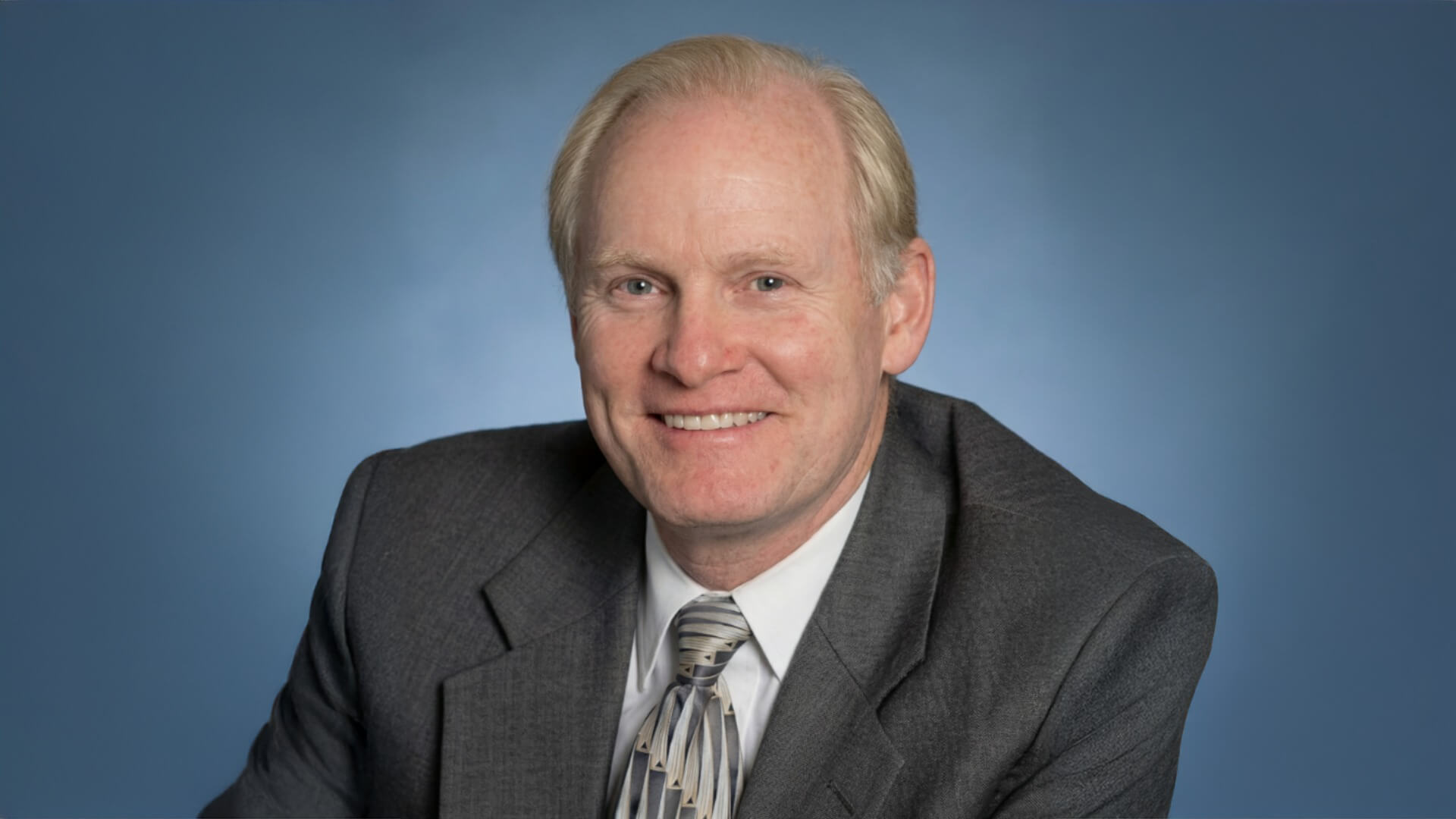 Smiling blonde businessman in gray suit